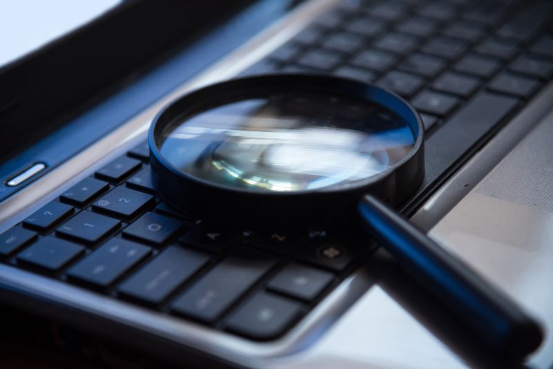 Magnifying glass on top of a laptop keyboard